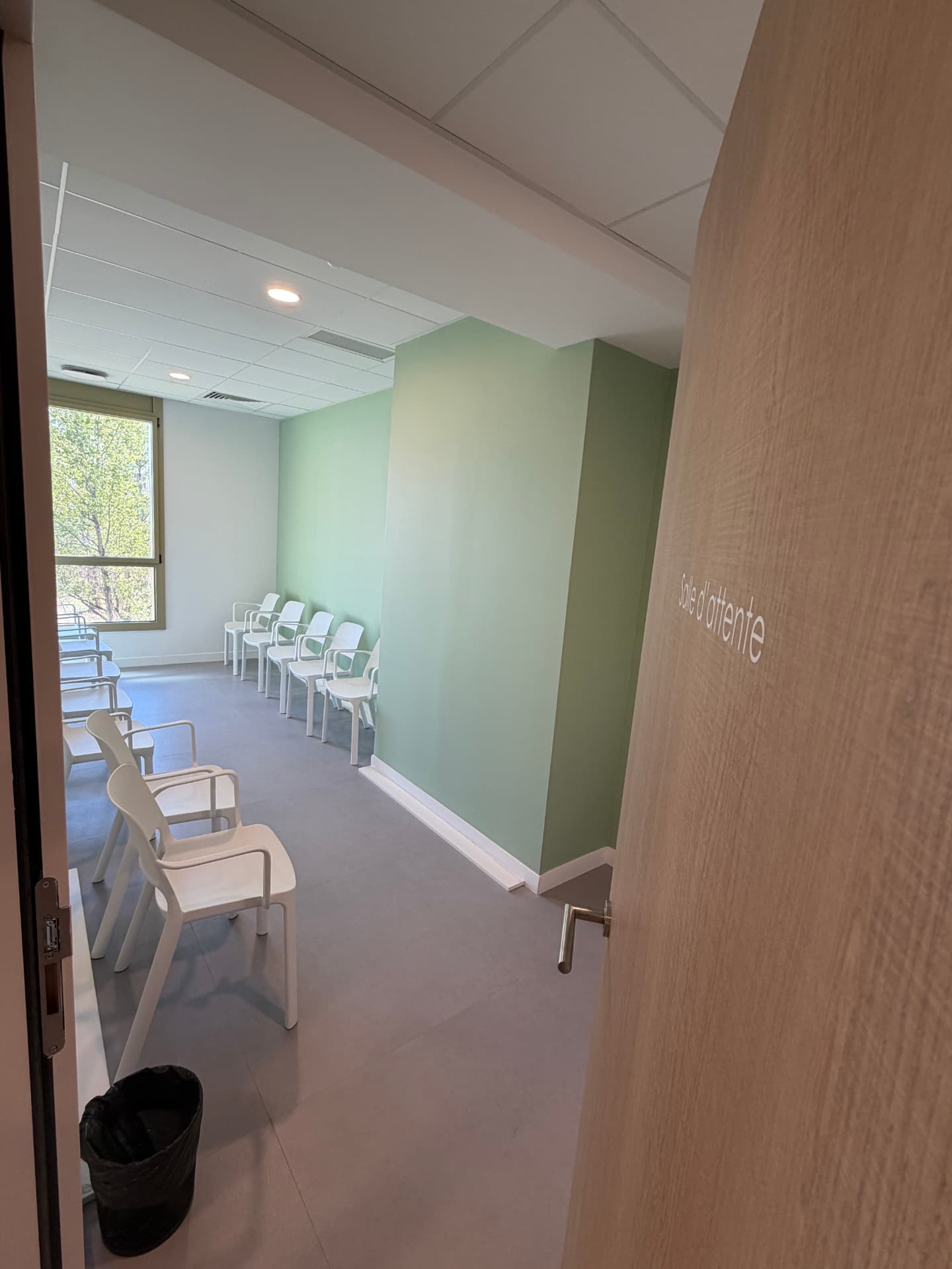 Salle d'attente aux murs vert d'eau du centre dentaire